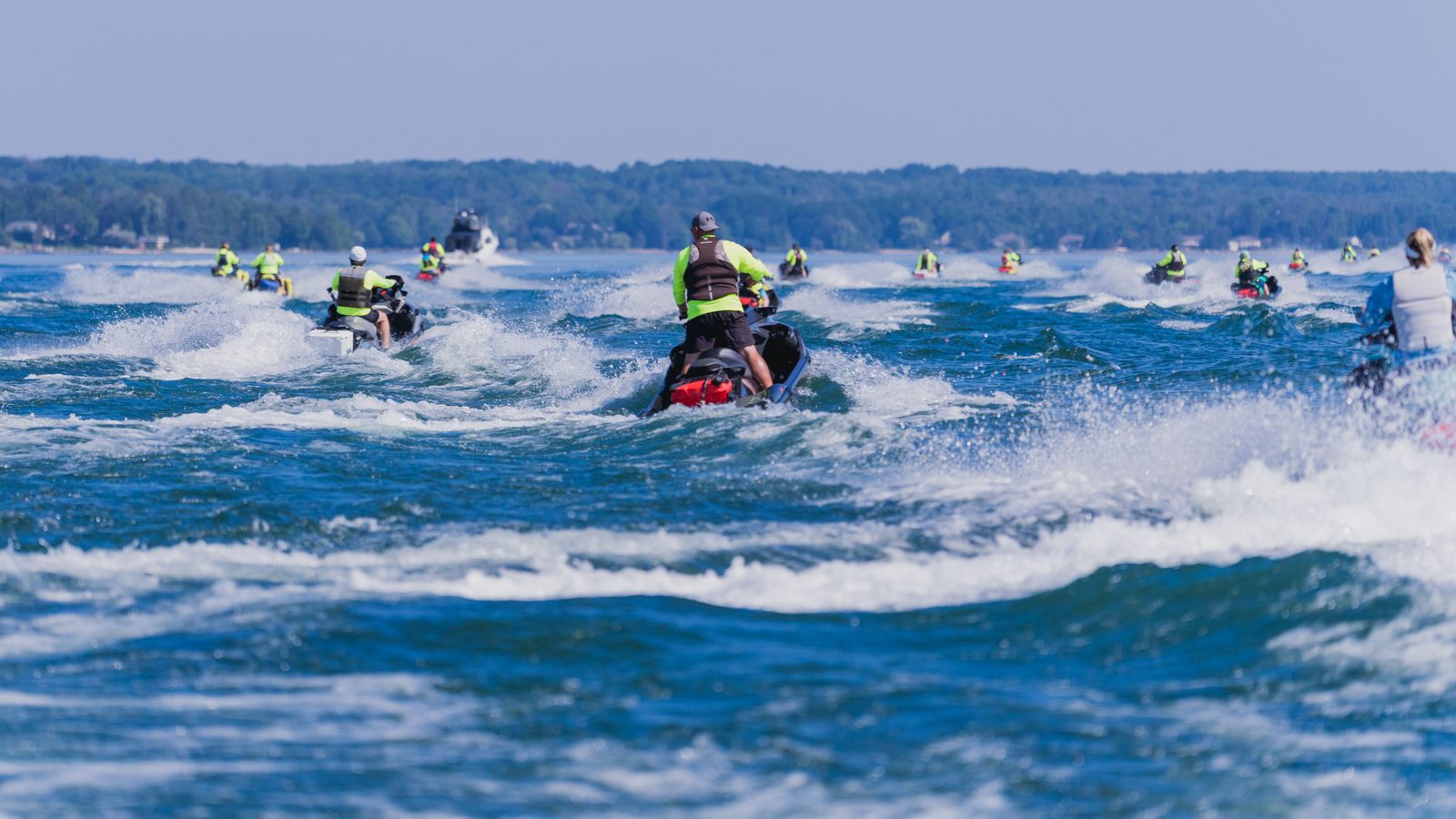 A line of Sea-Doos riding out across open water on a group ride