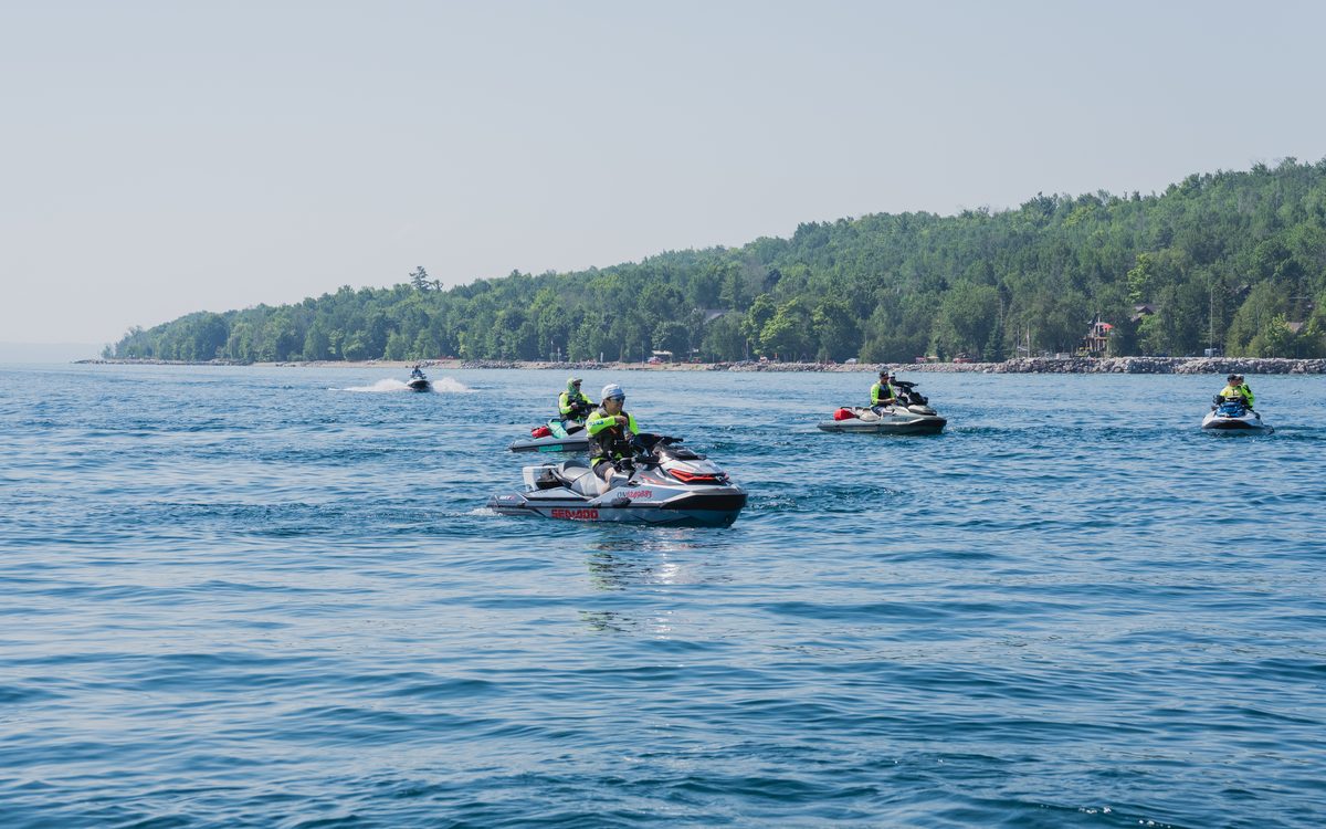 A Sea-Doo crossing open water along a treed Georgian Bay shoreline